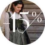 Eine Frau in einer Spitzenbluse und einem Spitzenkleid steht neben einer Treppe; darüber ist in großer weißer Schrift „-15 %“ eingeblendet.