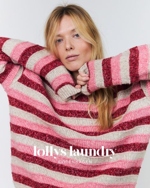 Eine Frau in einem rosa-rot gestreiften Pullover, die die Arme hochgestreckt vor einem weißen Hintergrund posiert. Unten steht der Schriftzug „Lollys Laundry Copenhagen“.