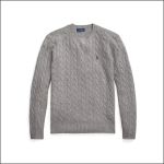 Ein grauer Pullover im Zopfmuster mit langen Ärmeln, gerippten Bündchen und Saum sowie einem kleinen gestickten Logo auf der linken Brust.